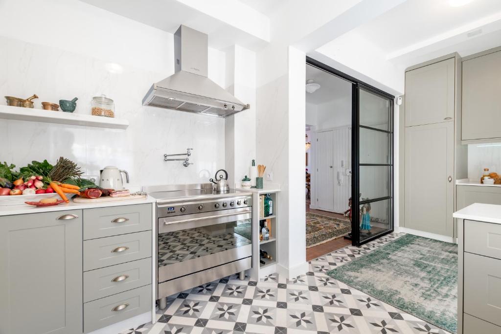 een witte keuken met een wastafel en een fornuis bij Casa da Avó Bia in Estremoz