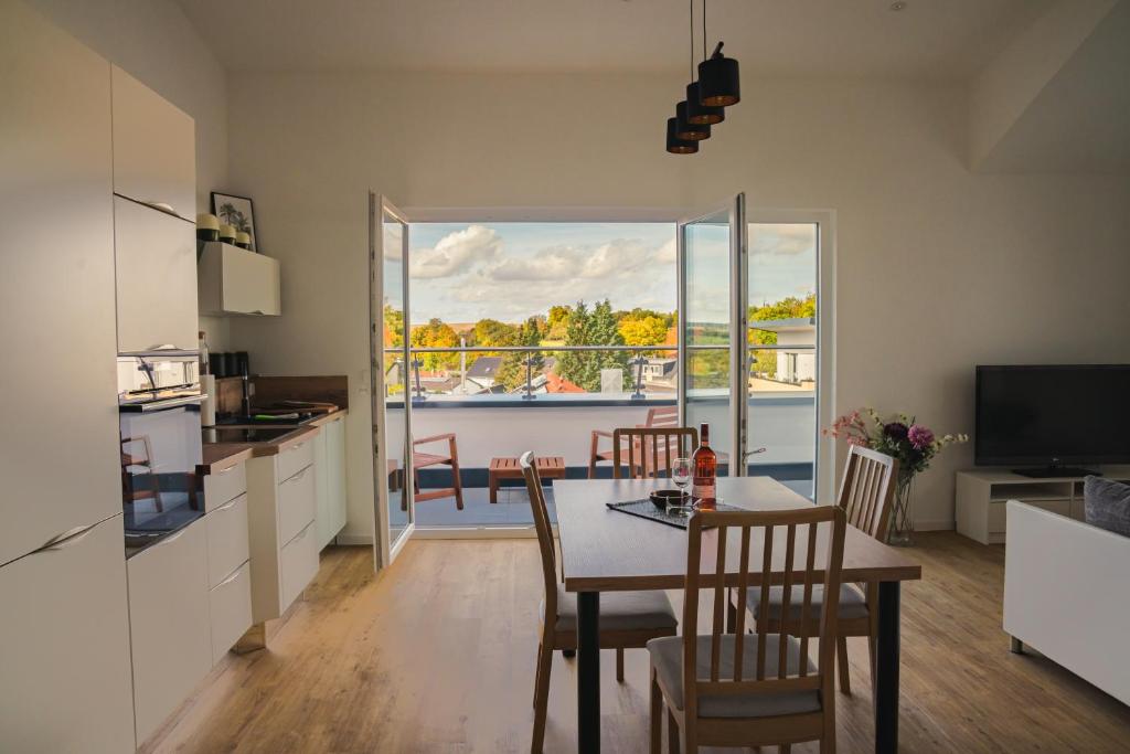 uma cozinha e sala de jantar com mesa e cadeiras em Panorama Suite 20 em Sinsheim