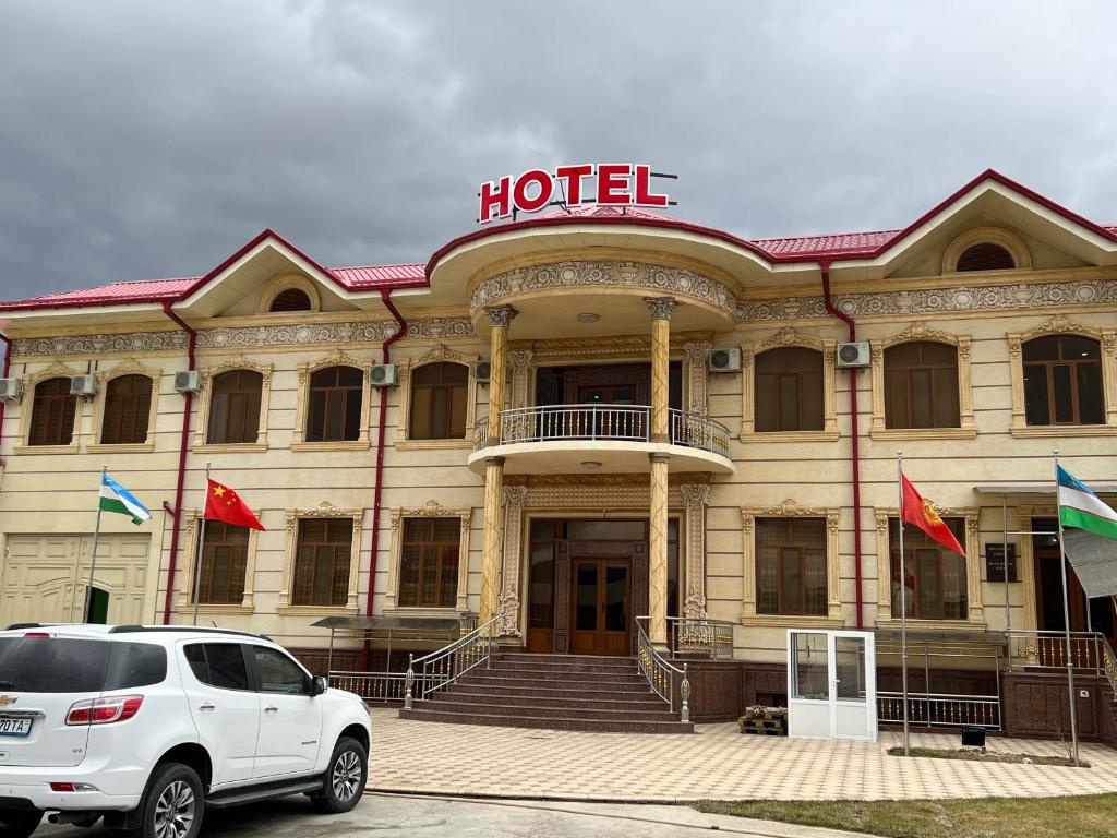 un coche blanco estacionado frente a un hotel en MOUNTAIN VIEW SAMARKAND, en Samarkand