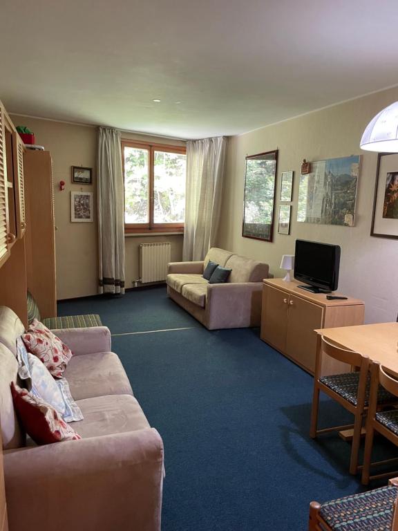 Sala de estar con 2 sofás y TV en Appartamento Val di Luce en Abetone