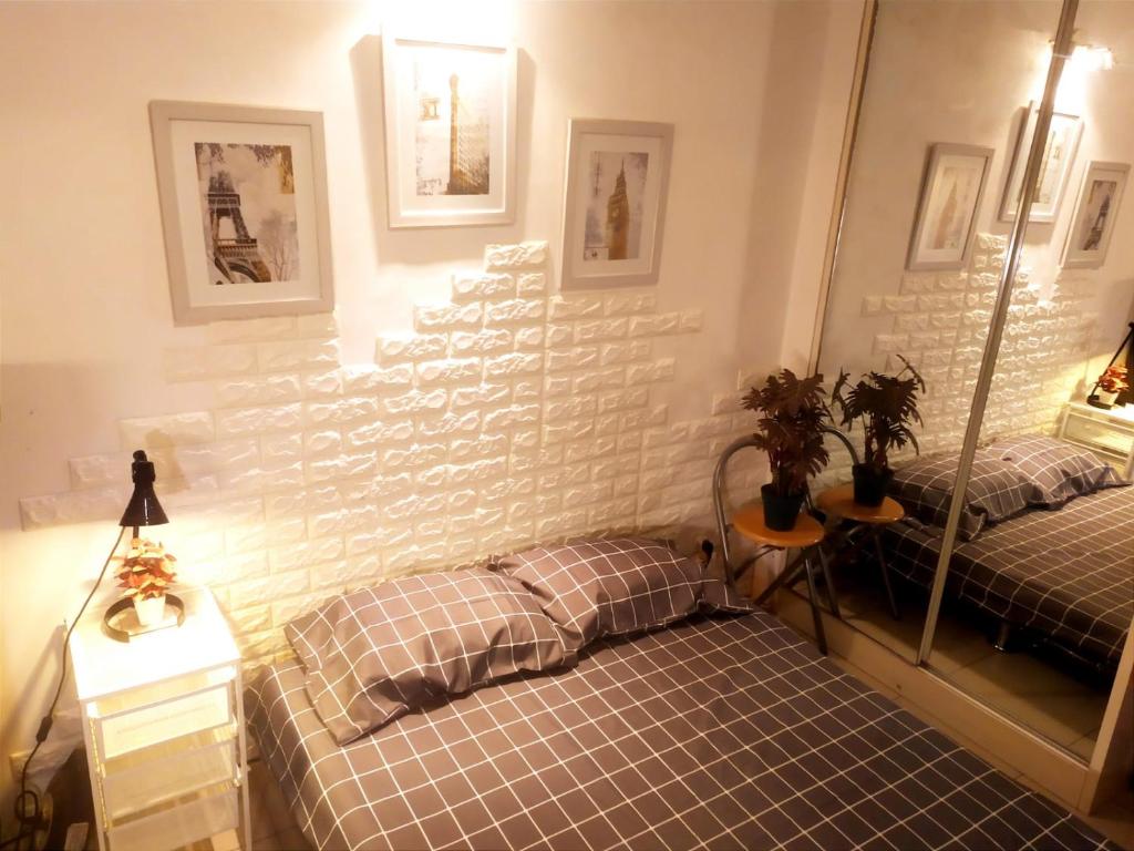 1 dormitorio con 2 camas y pared de ladrillo blanco en Tiny studio with pool, jogging track, gym and Mall en Yakarta