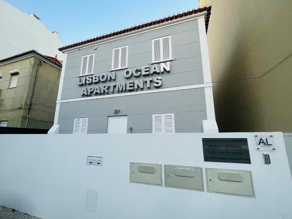 un bâtiment blanc avec un panneau sur son côté dans l'établissement Lisbon Ocean Apartments, à Costa da Caparica