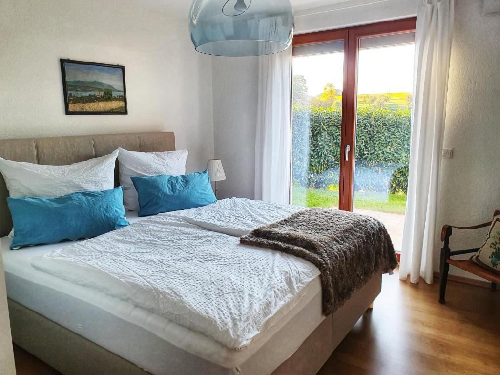 Waldenbuch的住宿－Komfort Appartement Panoramaweg，一间卧室配有一张带蓝色枕头的床和一扇窗户。