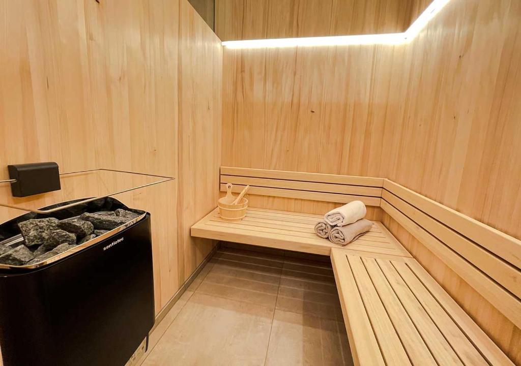 a room with a sauna with a bench and towels at Quality Hosts Arlberg - ALPtyrol Appartements in Sankt Anton am Arlberg