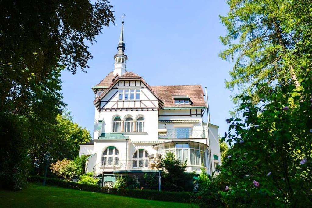 Una gran casa blanca con una torre encima. en Luxus Villa EMG Dortmund nah Düsseldorf, Köln, Essen, en Ennepetal
