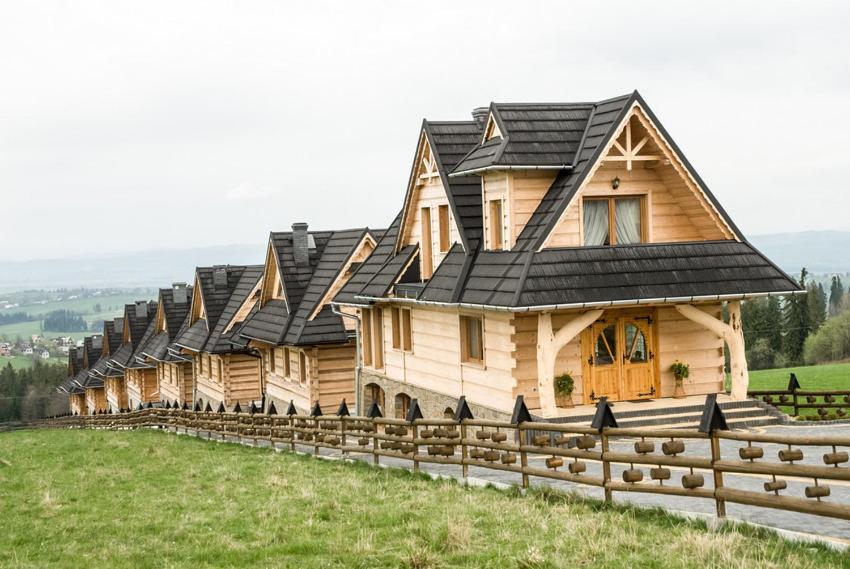 una fila de casas de madera en la cima de una colina en GÓRALOWE domki & SPA en Bańska