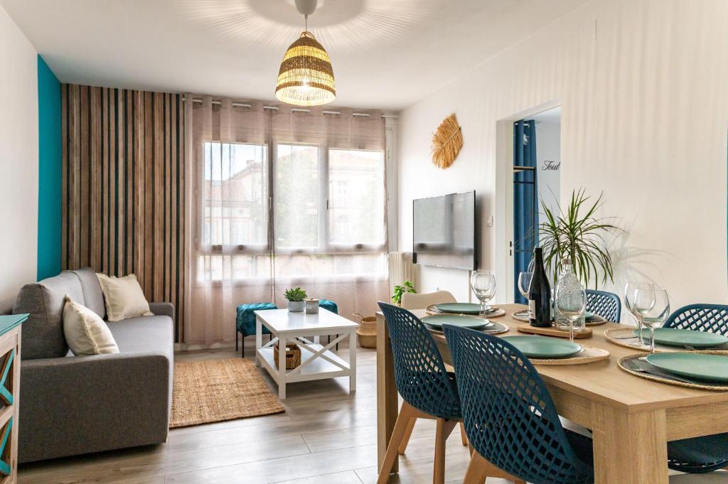 Reve bleu في مونتوبان: غرفة معيشة مع طاولة مع كراسي وأريكة