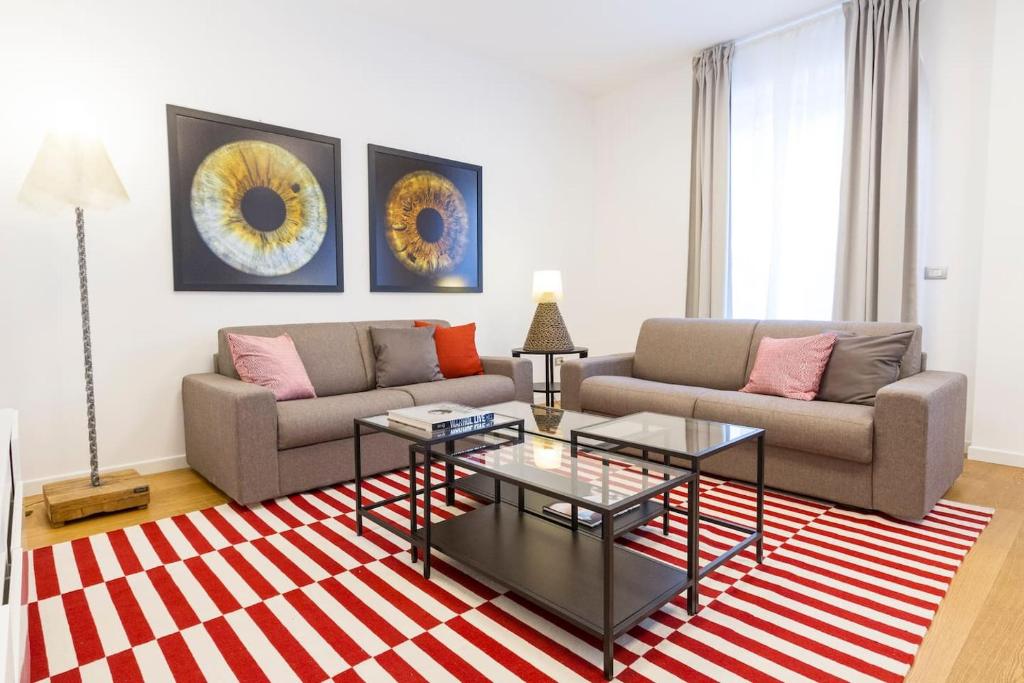 ein Wohnzimmer mit 2 Sofas und einem roten und weißen Teppich in der Unterkunft Easylife - Annydi Art Home in Duomo in Mailand