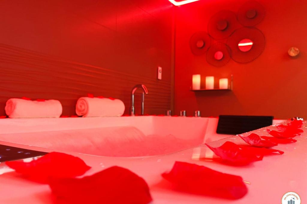 a red bathroom with a tub with red roses on it at l&#39;Orient-Express - Jacuzzi SPA - Parking - Loft in Le Havre