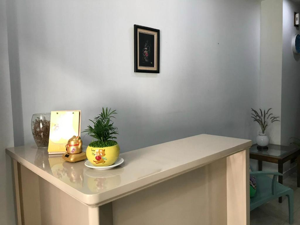 Biały stół z rośliną na górze w obiekcie Homestay TITO w Ho Chi Minh