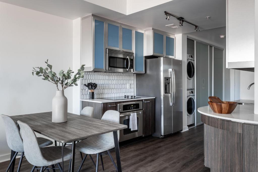 une cuisine avec des placards bleus et une table et des chaises en bois dans l'établissement Locale Lofts The Gulch - Nashville, à Nashville