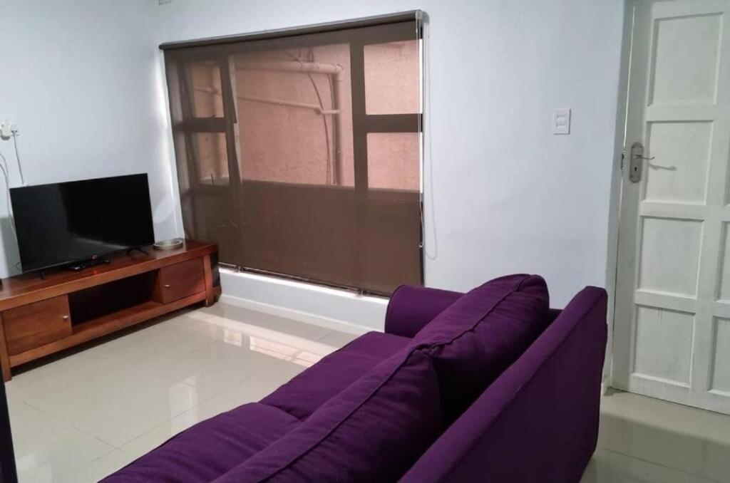 un soggiorno con un divano viola e una TV di CZ Kubs 47 a East London