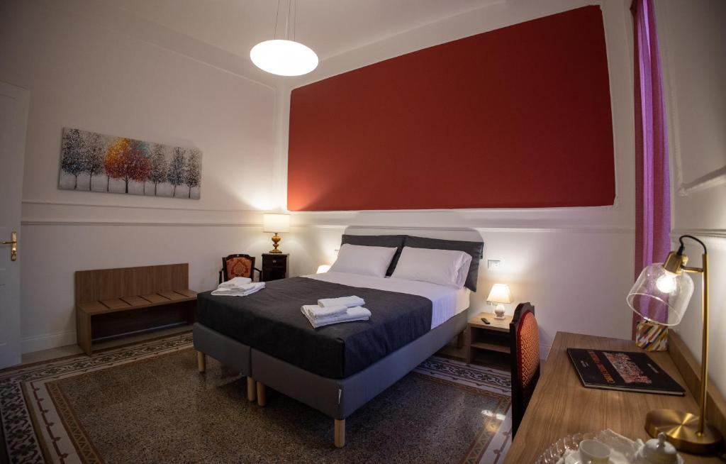 ein Schlafzimmer mit einem Bett und einem Tisch mit Handtüchern darauf in der Unterkunft Petrarca Suite in Palermo