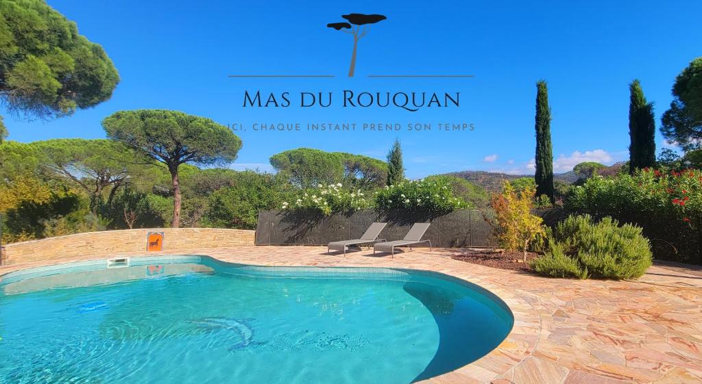 a swimming pool in a yard with benches and trees at Le Mas du Rouquan in Vidauban