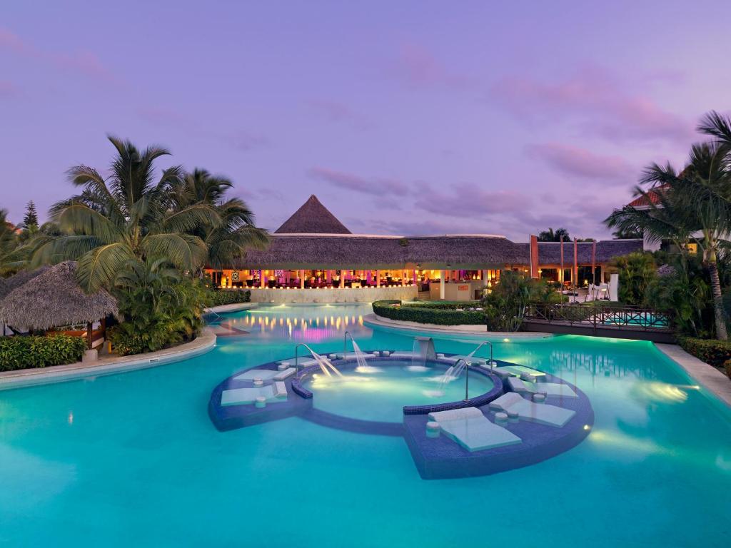 una piscina resort con agua azul por la noche en Garden Suites by Meliá - All inclusive, en Punta Cana