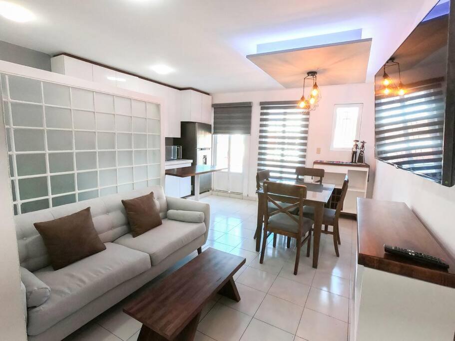 uma sala de estar com um sofá e uma mesa em San Felipe Apartament em Uruapan