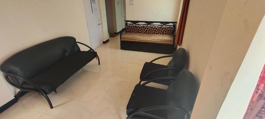 een kamer met stoelen en een bed in een kamer bij Rutugandh Homestay Wai, Near Panchgani in Wai