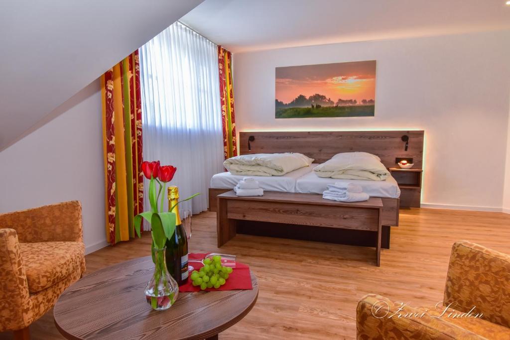 - une chambre avec un lit et une table ornée d'un vase de fleurs dans l'établissement Hotel Zwei Linden - links der Elbe - Niedersachsen, à Balje