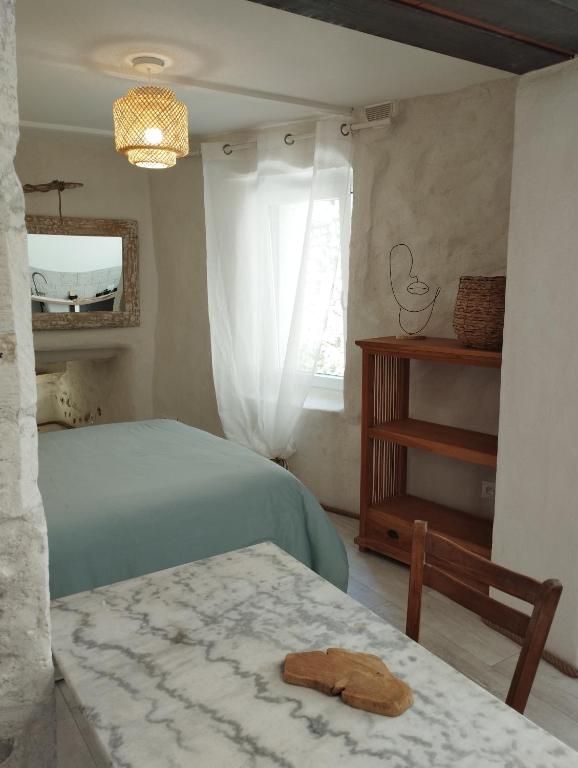 une chambre avec un lit, une table et une fenêtre dans l'établissement Le nid des filles, à Dions