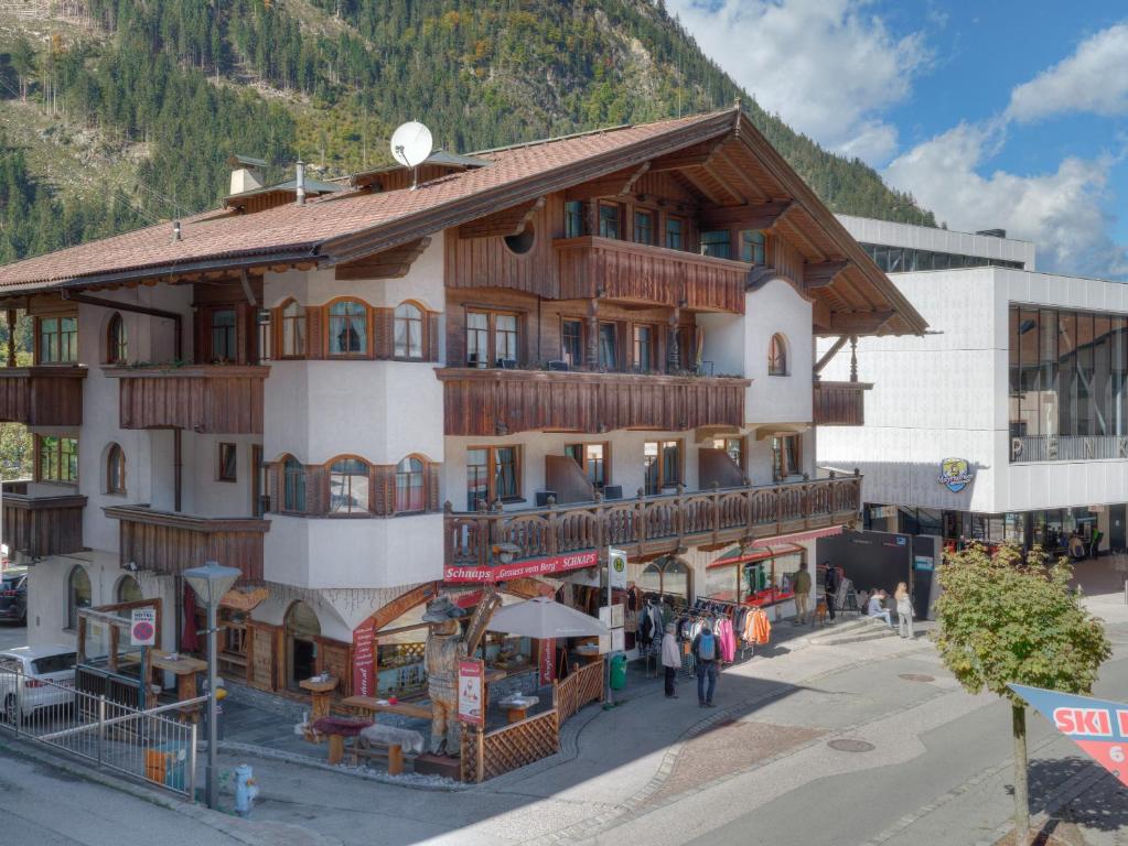 un grand bâtiment avec des personnes qui marchent devant lui dans l'établissement Center Rooms & Apartments, à Mayrhofen