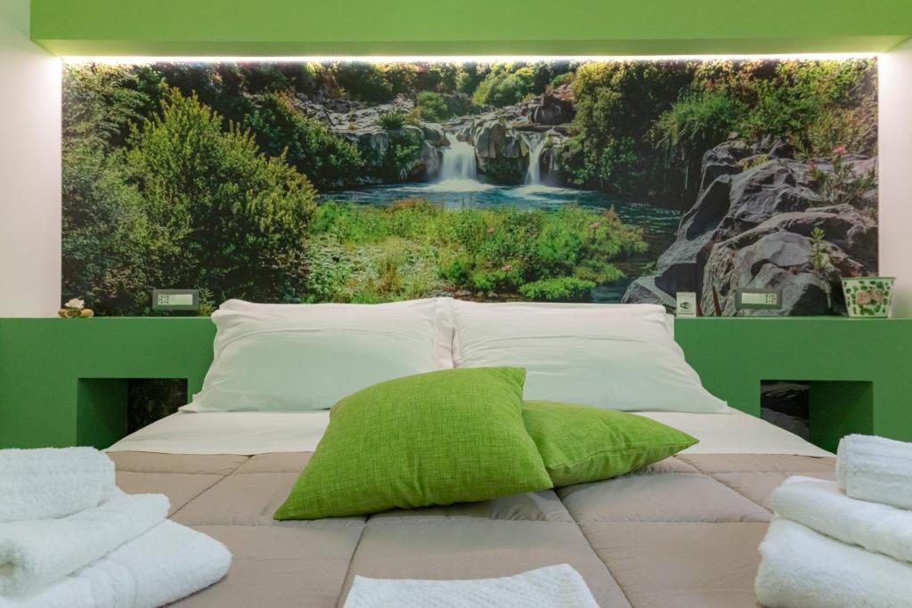 een bed met een watervalmuurschildering aan de muur bij LN ETNA HOUSE-villa ad uso esclusivo in Pedara