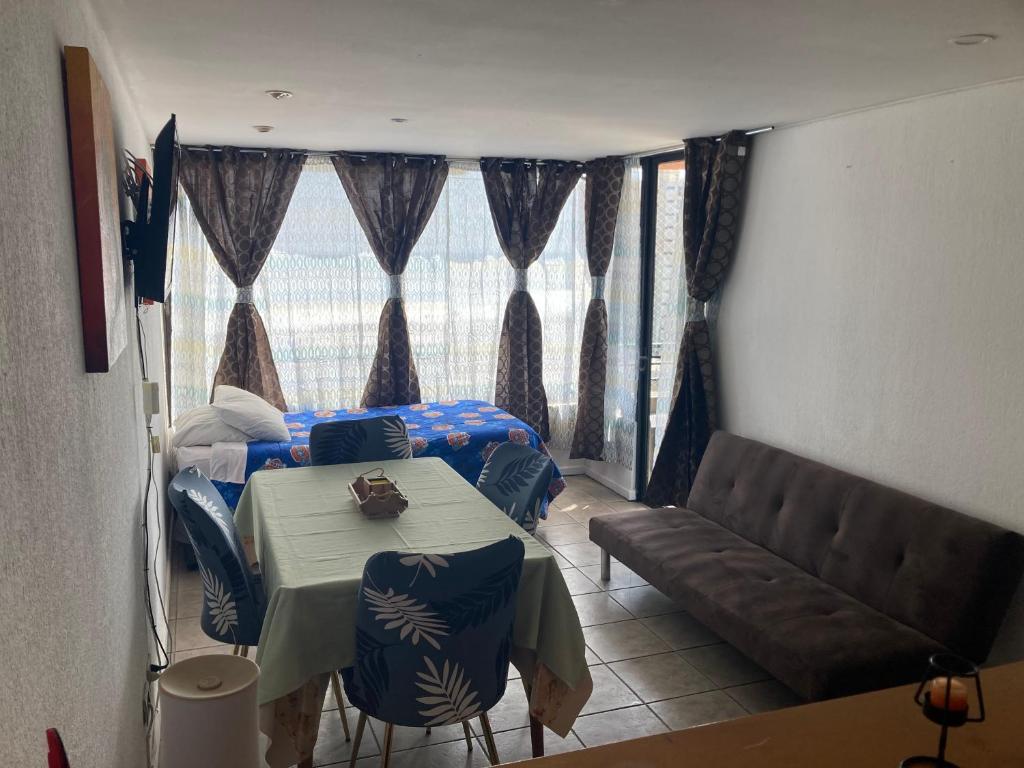 a living room with a table and a couch at Amoblados MyK playa brava club in Iquique