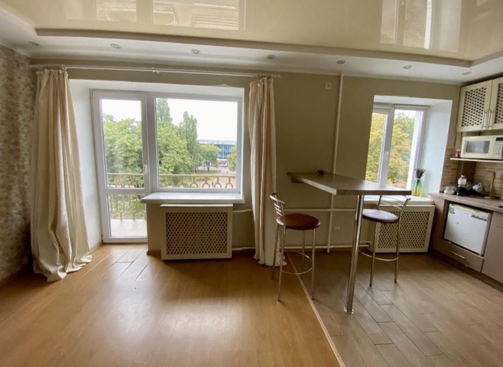 a kitchen with a table and chairs and a window at Квартира в центрі Світлі мрії Avenue Myru35 in Chernihiv