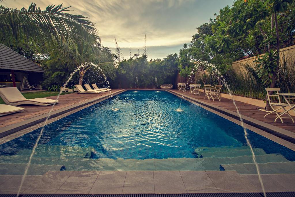 a swimming pool with water faucets in a yard at Pledge 3 in Negombo