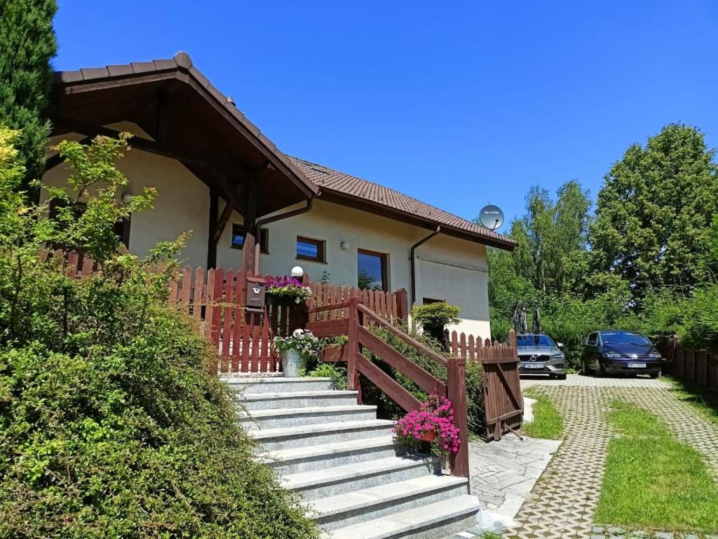 dom z drewnianym płotem i schodami przed nim w obiekcie Słoneczne Wzgórze w mieście Duszniki Zdrój