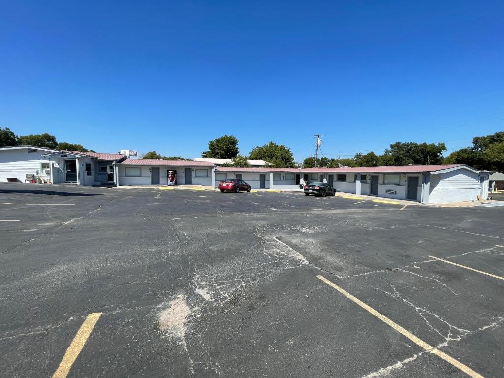 un estacionamiento vacío frente a un motel en Budget Inn Madill, en Madill