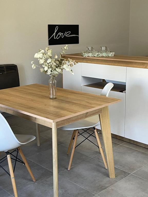 een houten tafel met een vaas met bloemen erop bij 3H MALARGÜE Monoambiente in Malargüe