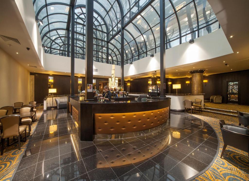 um lobby de um hotel com um bar em President Hotel em Londres