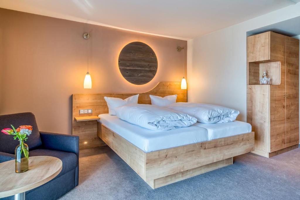 ein Schlafzimmer mit einem Bett, einem Tisch und einem Stuhl in der Unterkunft Hotel Beckmann in Göttingen