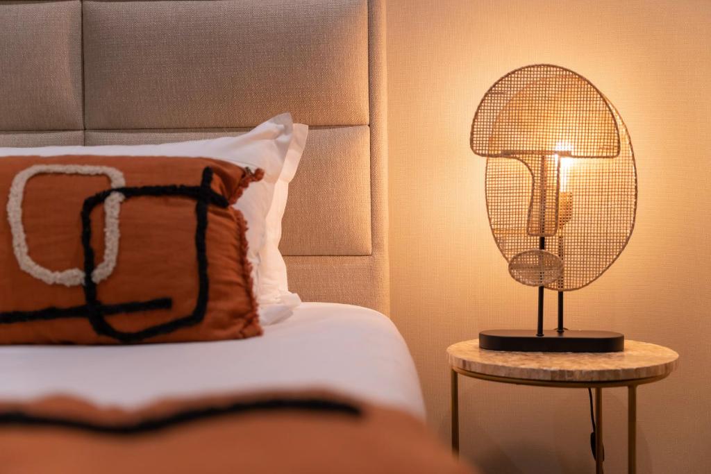 a lamp on a table next to a bed at Palm Beach in Ajaccio