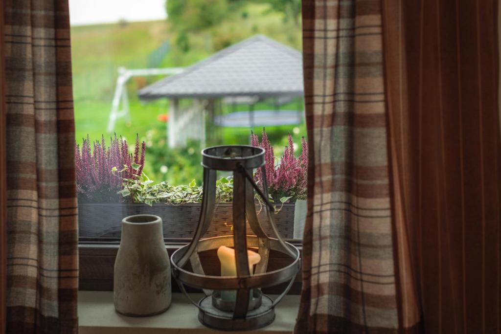 a window sill with a vase and a vase at Apartamenty U Harrego I Przy Stawie Spa in Kudowa-Zdrój