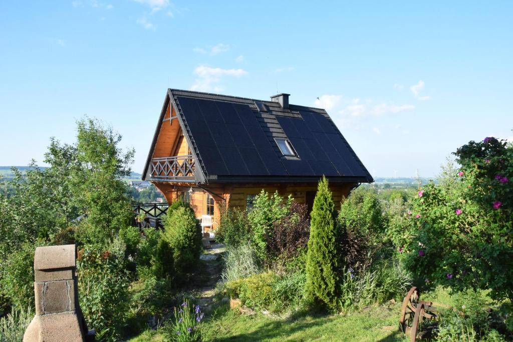 a house with solar panels on the roof at Dom Letnisowkowy Basiówka in Bodzentyn