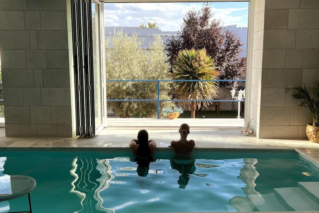 2 personnes assises dans une piscine dans une maison dans l'établissement Casa de los Recuerdos, à Cuéllar