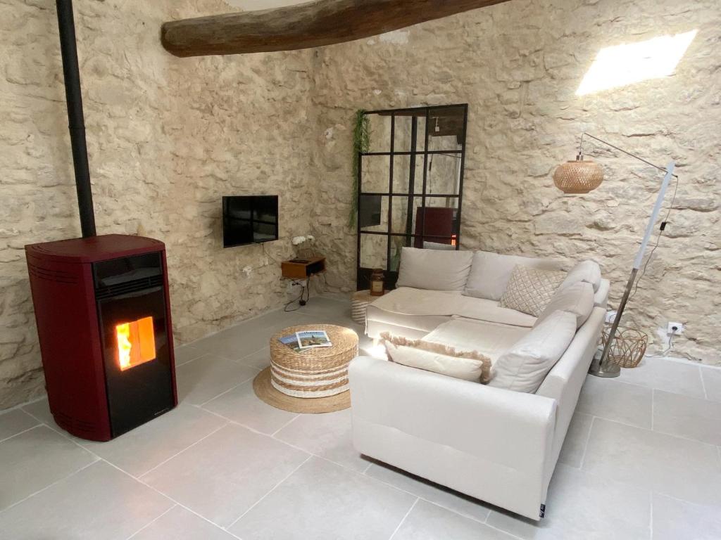 a living room with a white couch and a fireplace at Bonnieux : Loft - La pause in Bonnieux