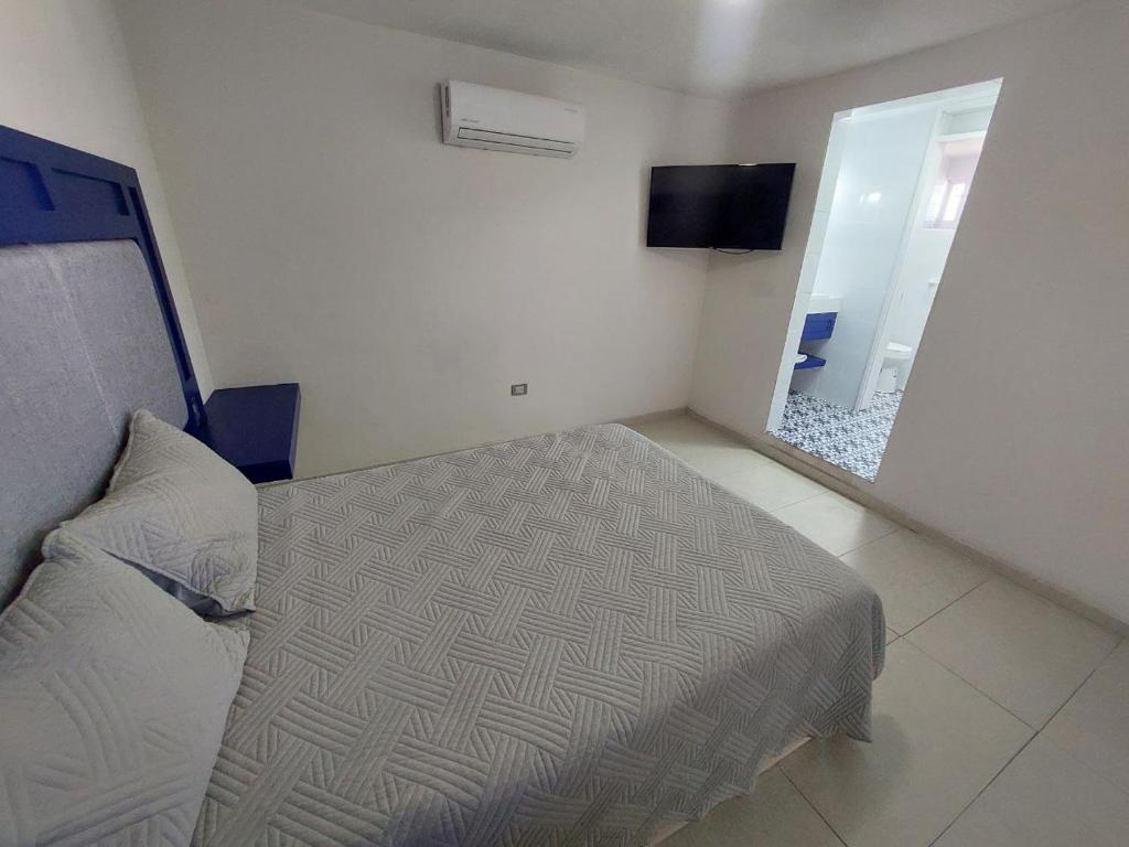 杜蘭戈的住宿－HN Hotel，一间小卧室,配有一张床和镜子