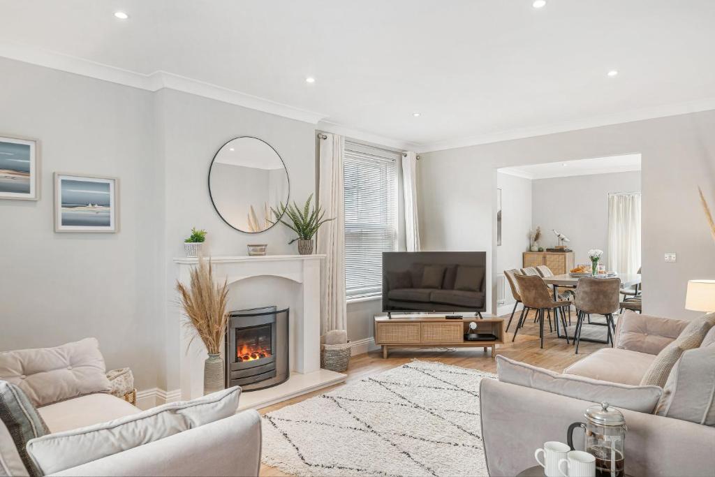 a living room with a fireplace and a tv at Estura in Uny Lelant