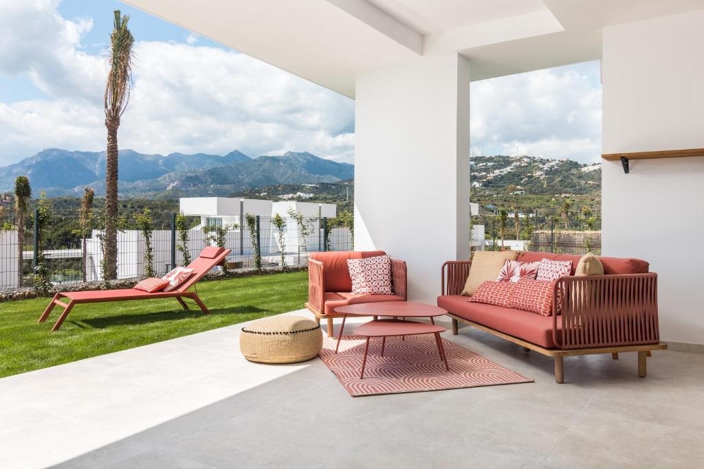 un soggiorno con 2 sedie e un tavolo di Exclusive New Apartment within Santa Clara and Marbella Golf & Country Club a Marbella
