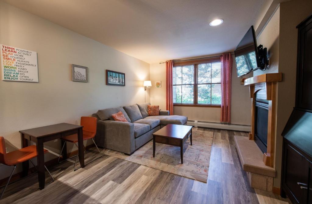 ein Wohnzimmer mit einem Sofa und einem Tisch in der Unterkunft Zephyr Mountain Lodge Premium-Rated 1102 in Winter Park