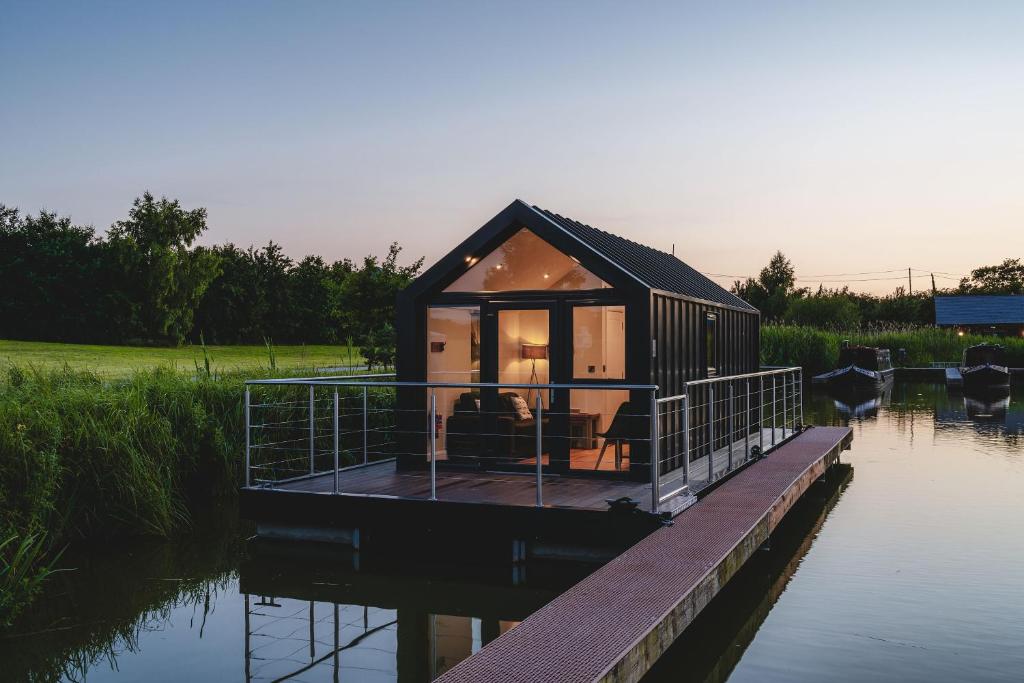 a tiny house on a dock in the water at Whimbrel in Tattenhall