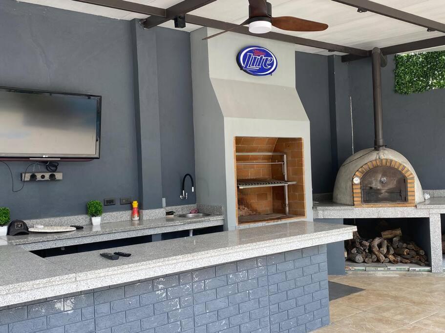 cocina al aire libre con TV y chimenea en Linda suite para hospedarte en la Final, en Guayaquil