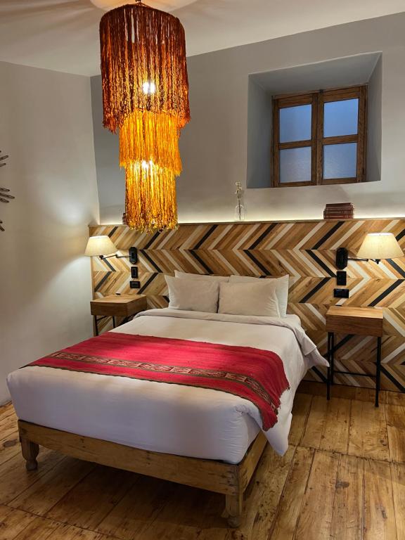 a bedroom with a bed and a chandelier at Casa Tunki in Cusco