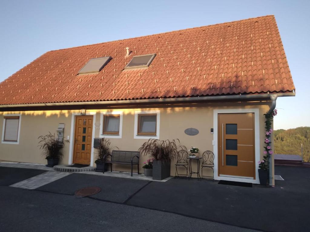 a white house with an orange roof and two doors at Appartement Fam.Kremser in Leutschach