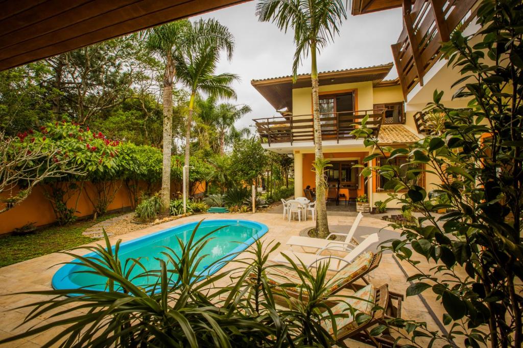 a house with a swimming pool in front of a house at Pousada Tulipane Florianopolis in Florianópolis