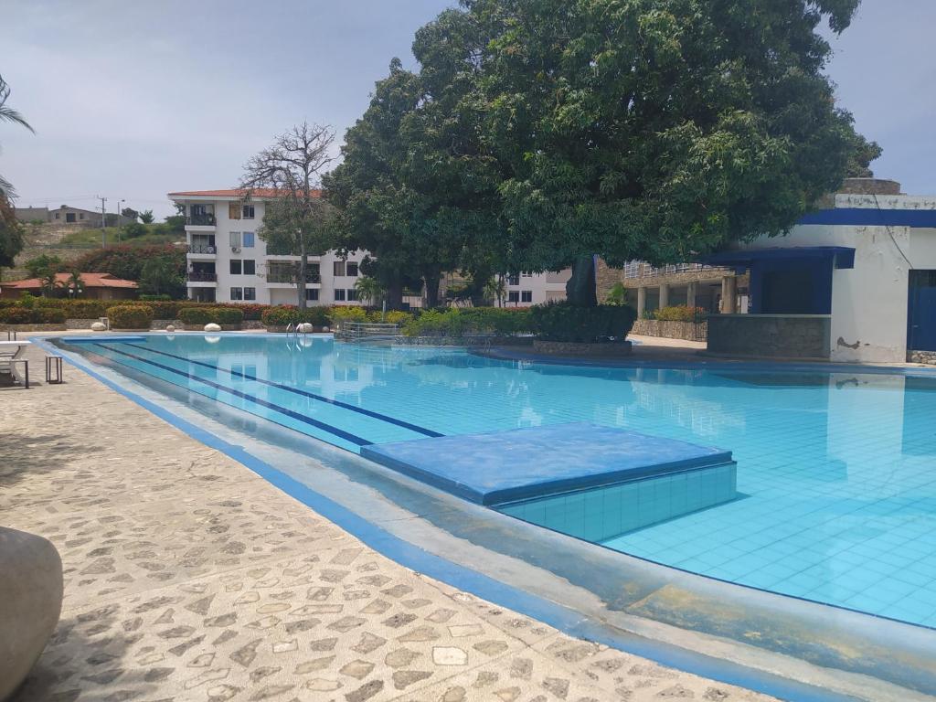 a large swimming pool with blue water at Cabaña Parejas y Familias Condominio Campestre cerca Rodadero con Piscinas in Santa Marta