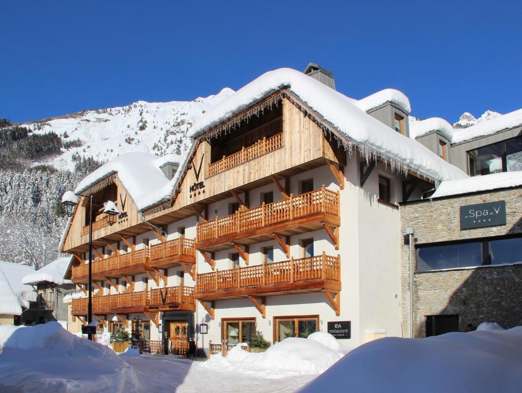 un grand bâtiment avec de la neige sur le toit dans l'établissement Hotel Le V de Vaujany, à Vaujany