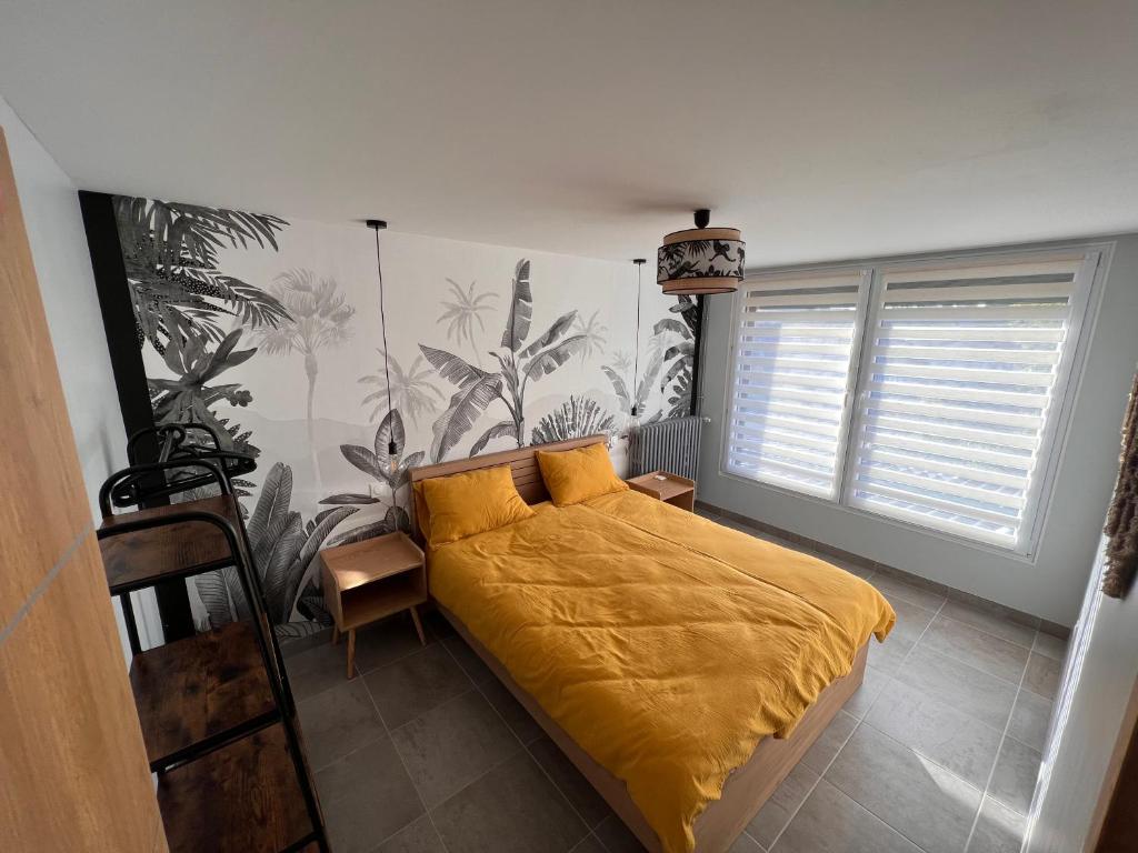 a bedroom with a bed with a yellow blanket at Suite "Olga 1 " in Verdun-sur-Meuse